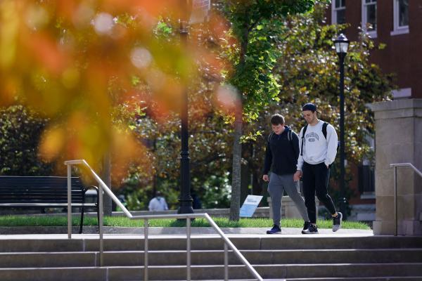 Students walk on campus amidst fall foliage