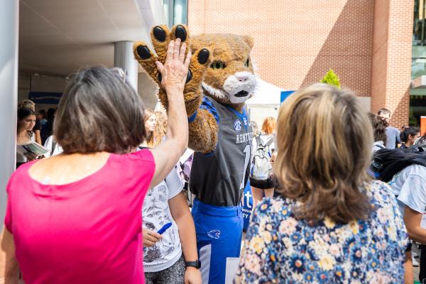 Photo of Wildcat high-fiving member of community