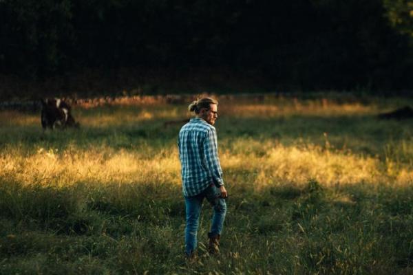 Man wearing jeans standing in field 