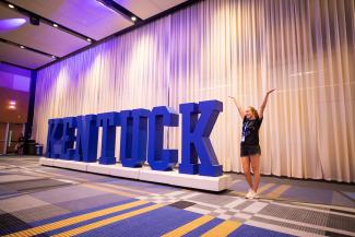 Photo of student with "Kentucky" sign