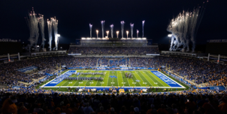 Photo of University of Kentucky's Kroger Field at night, under lights, with fireworks shooting in the sky