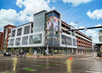 The Cornerstone at UK with wet, reflective streets and a partly cloudy sky.