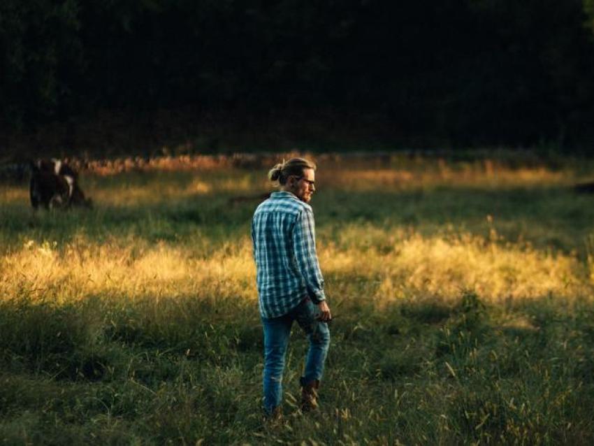 Man wearing jeans standing in field